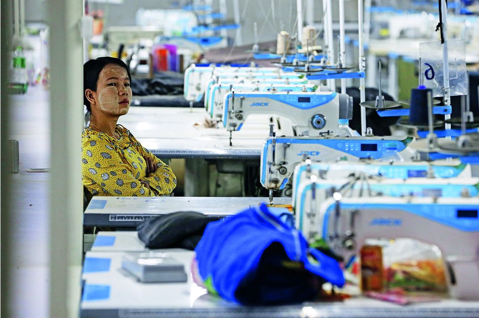 3月6日，在緬甸仰光市郊的Shwe Pyi Thar工業區，一名工人坐在一家制衣廠的車間里。工人們占據了這家新近關閉的制衣廠，要求支付工資和加班費。受新冠肺炎疫情影響，來自中國的供應鏈中斷，緬 甸的紡織業受到沉重打擊。