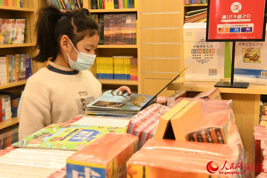 邯鄲市廣平縣的小朋友在人民路新華書店內(nèi)閱讀書籍。 程學虎攝