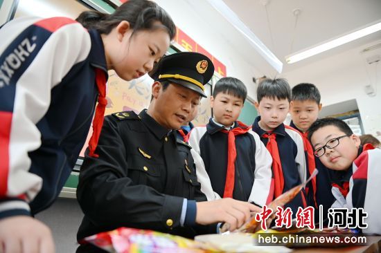 圖為叢臺區(qū)市場監(jiān)督管理局工作人員在中華橋小學，指導學生們辨認假冒過期食品。 作者 周紹宗